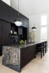 Modern country-style kitchen with custom oak cabinetry, honed granite countertops, and an oversized island in a Hudson Valley retreat.