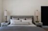 Modern mountain home bedroom featuring handwoven textiles, natural materials, and large windows overlooking the Hudson Valley woods.