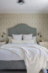 Bedroom with coastal interior design, natural linen and jute interiors, and elegant furnishings in a Westchester heritage home.