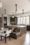 Contemporary residence Short Hills kitchen with large island, built-in bench seating, globe pendants, and tall windows