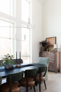 Open-concept dining room with wood beam ceiling and modern furnishings in a contemporary Hudson Valley mountain home.