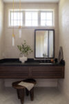 Contemporary Residence Short Hills bathroom vanity with dark wood cabinetry, black countertop, mirror, and pendant lighting