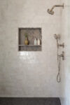 Contemporary Residence Short Hills bathroom shower with tiled walls, recessed niche, and streamlined shower fixtures