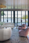 Family room with steel-framed windows and French doors overlooking Long Island Sound in a coastal heritage home.