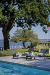 Poolside area of Westchester luxury estate with Long Island Sound in the background.