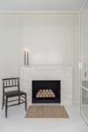 Marble fireplace with hand-applied plaster surround and white oak millwork in transitional family living room.