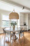 Victorian farmhouse kitchen dining area with a circular table, painted beams, and warm layered textures in a historic Westfield NJ home renovation.