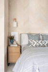 Bedroom with tan chevron-patterned accent wall in a Westfield NJ classic modern home, featuring soft textures and transitional design.