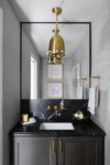 Guest bathroom in Westfield New Jersey featuring dramatic black marble, brass fixtures, and modern updates.