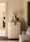 Luxury whole house renovation NJ living room detail with tall storage cabinet, sculptural wall lamp, and stacked decor