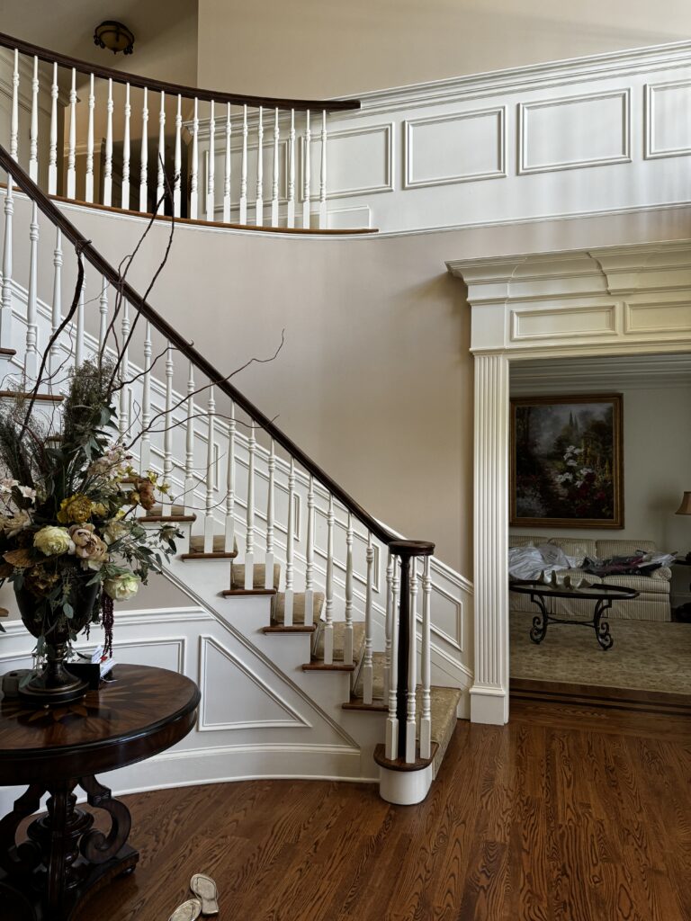 before image of traditional entryway with curved staircase white trim wood railing and hardwood flooring