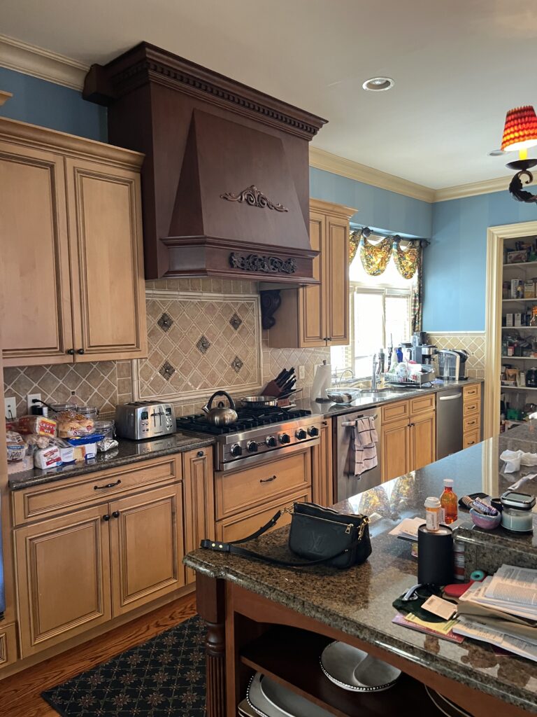 before image of traditional kitchen with wood cabinetry granite countertops decorative range hood and tile backsplash