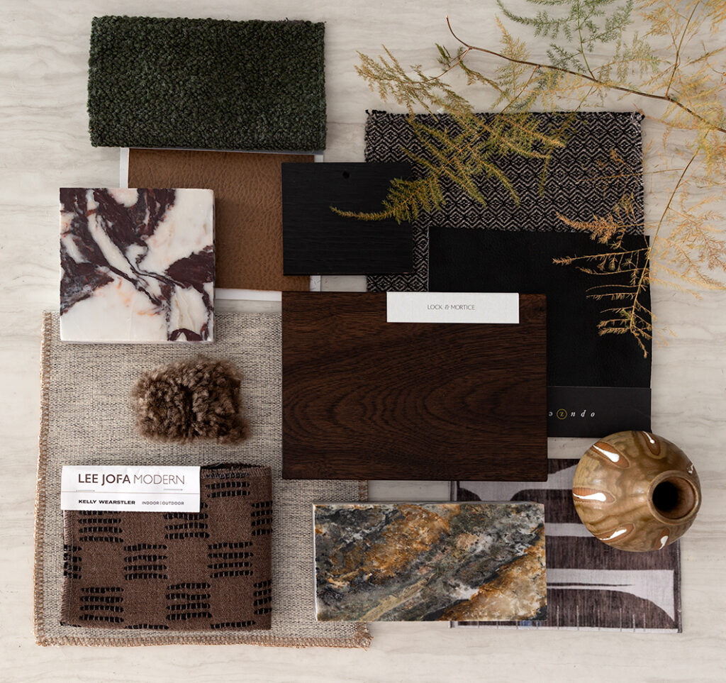 Flat lay of luxury interior design materials featuring marble and stone samples, rich wood finishes, textured fabrics, carpet, and metal finishes used to create a warm, timeless design palette.