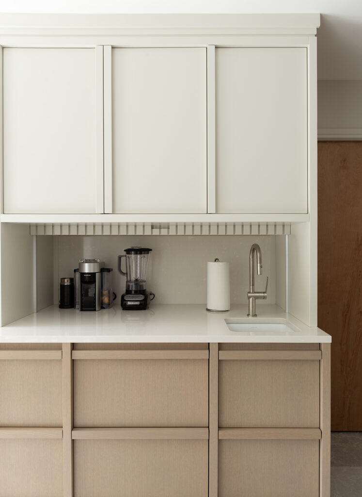 Custom coffee bar with built-in cabinetry, sink, appliances, and minimalist storage