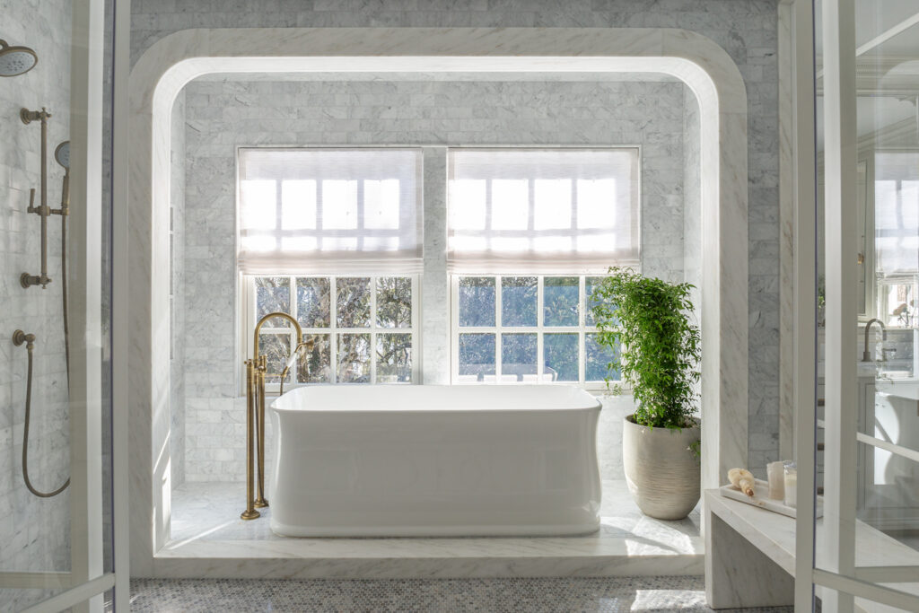 Transitional bathroom with freestanding bathtub, brass fixtures, and soft neutral palette.