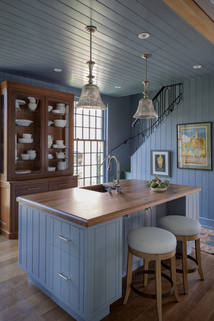 Basement bar with island in a Westchester luxury estate featuring fluted wood, brass finishes, and coastal textures.