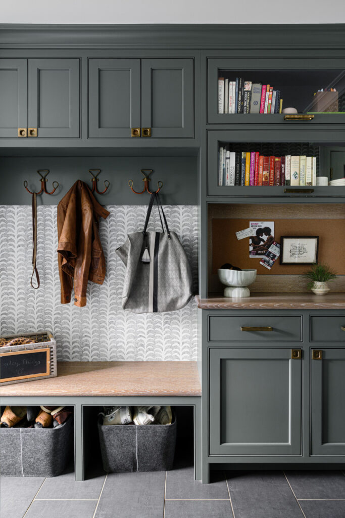 Transitional mudroom in Westfield New Jersey featuring herringbone porcelain tile, custom built-in cubbies with charging stations, and a bench with hidden shoe storage.