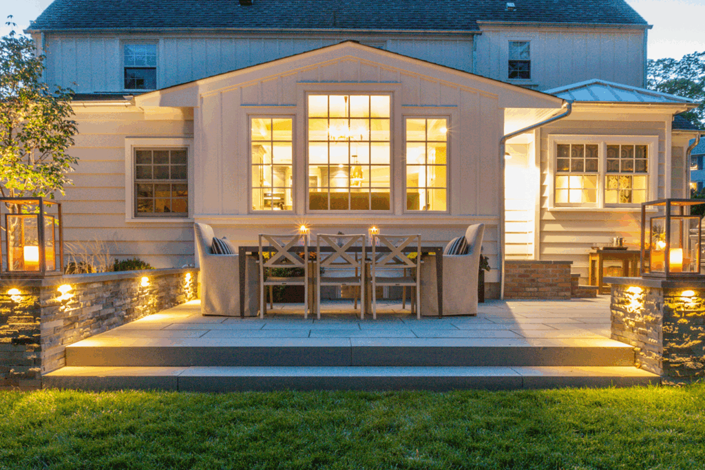 Evening view of a Westfield NJ white cottage-style home with illuminated windows and classic modern architectural details.